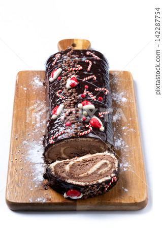 Christmas chocolate yule log cake with festive decorations Christmas chocolate yule log cake with festive decorations 142287754