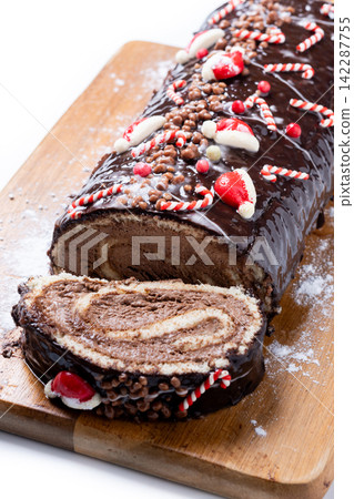 Christmas chocolate yule log cake with festive decorations 142287755