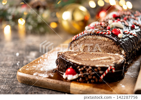 Christmas chocolate yule log cake with festive decorations Christmas chocolate yule log cake with festive decorations 142287756