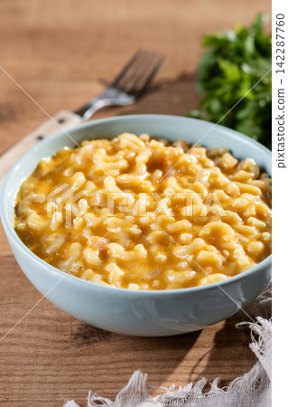 Traditional mac and cheese in bowl on wooden table Traditional mac and cheese in bowl on wooden table 142287760
