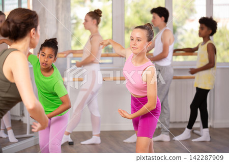 Teenage girls doing choreography with instructor during ballet classes Teenage girls doing choreography with instructor during ballet classes 142287909