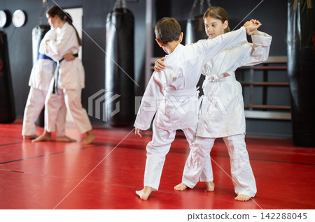 Boy and girl train judo in pairs Boy and girl train judo in pairs 142288045