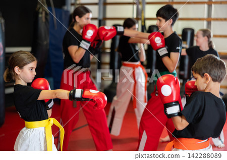 Boy and girl practice boxing in pairs Boy and girl practice boxing in pairs 142288089
