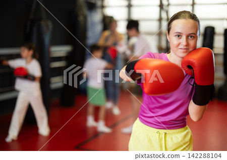 Teenage girl in boxing gloves in training Teenage girl in boxing gloves in training 142288104
