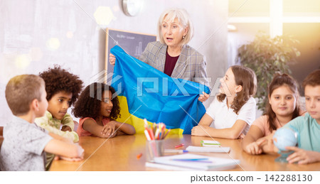 Friendly female teacher tells the pupils the history of Ukraine Friendly female teacher tells the pupils the history of Ukraine 142288130