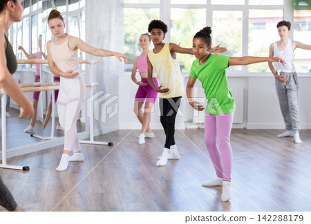 Group of teenage dancers training ballet in studio Group of teenage dancers training ballet in studio 142288179