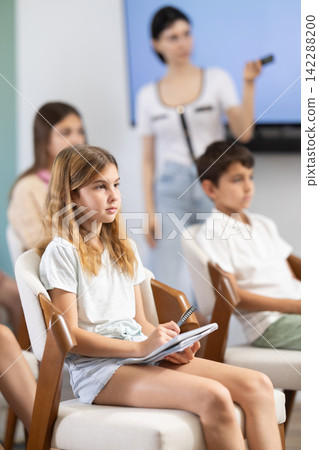 During lecture meeting at class, teens and preteens pupil listen to female teacher During lecture meeting at class, teens and preteens pupil listen to female teacher 142288200