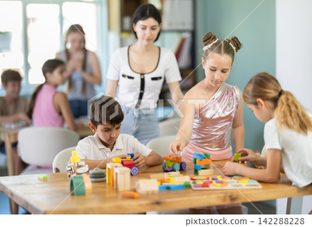 Preteens playing with wooden blocks at educational children's club Preteens playing with wooden blocks at educational children's club 142288228