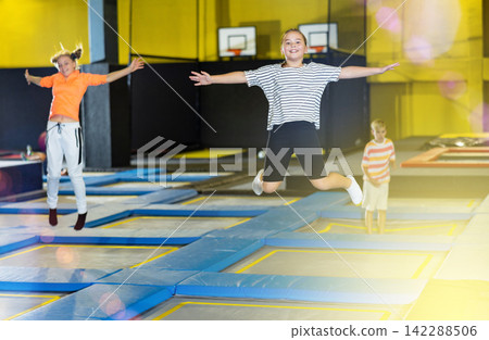 Happy cute little girl jumping on trampoline indoors Happy cute little girl jumping on trampoline indoors 142288506
