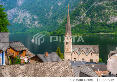 Hallstatt, Austria. A view of Lake Hallstatt and the village against the backdrop of the lush green Alps. Hallstatt, Austria. A view of Lake Hallstatt and the village against the backdrop of the lush green Alps. 142288956