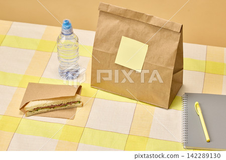Packed student lunch with sandwich, water and school stationery Packed student lunch with sandwich, water and school stationery 142289130
