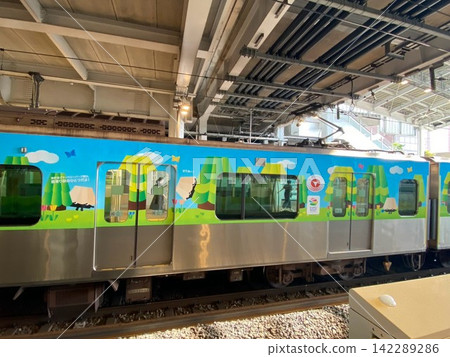 A station scene featuring a colorful, wrapped train with designs from the International Horticultural Exposition GREEN×EXPO 2027. A station scene featuring a colorful, wrapped train with designs from the International Horticultural Exposition GREEN×EXPO 2027. 142289286