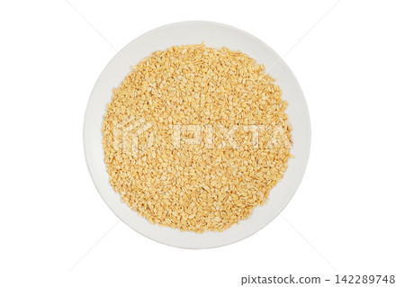 Oatmeal on a ceramic plate isolated on a white background. Vegetarian organic food. Grain for vegetarians. Contains soluble fiber, which improves stomach and intestinal function. Top view. Oatmeal on a ceramic plate isolated on a white background. Vegetarian organic food. Grain for vegetarians. Contains soluble fiber, which improves stomach and intestinal function. Top view. 142289748