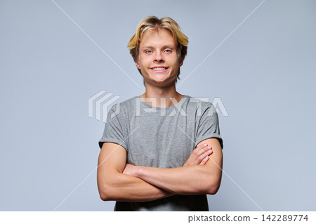 Portrait of confident smiling teenage boy with crossed arms 142289774