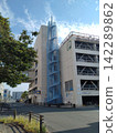 A multi-story parking garage with a blue emergency staircase (sunny day) 142289862
