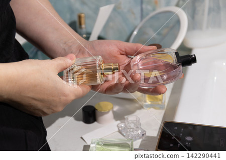 Dual Fragrance Display: Two Perfume Bottles Held on a Bathroom Vanity Dual Fragrance Display: Two Perfume Bottles Held on a Bathroom Vanity 142290441