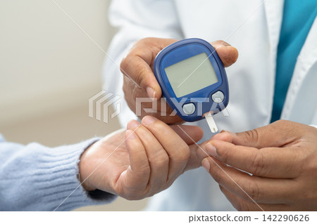 Doctor check diabetes from finger blood sugar level with finger lancet. Doctor check diabetes from finger blood sugar level with finger lancet. 142290626