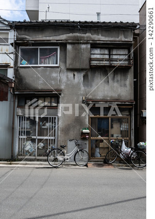 這座昭和時代建造的老式復古風格兩層排屋,其斑駁的砂漿牆壁和裂縫訴說著一段歷史。 這座昭和時代建造的老式復古風格兩層排屋,其斑駁的砂漿牆壁和裂縫訴說著一段歷史。 142290661