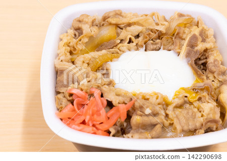 A delicious beef bowl bento box topped with pickled ginger and a soft-boiled egg. A delicious beef bowl bento box topped with pickled ginger and a soft-boiled egg. 142290698