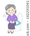 A senior woman sitting on the toilet, clutching her stomach in pain. 142291041