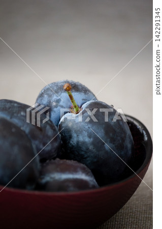 Macro photo of fresh ripe purple plums with water drops Macro photo of fresh ripe purple plums with water drops 142291345