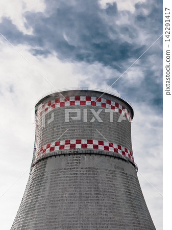 Cooling tower of an industrial plant or thermal power plant against a blue sky Cooling tower of an industrial plant or thermal power plant against a blue sky 142291417