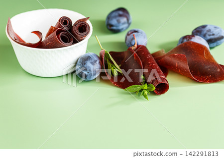 Homemade dried plum dessert with rolls on green background Homemade dried plum dessert with rolls on green background 142291813