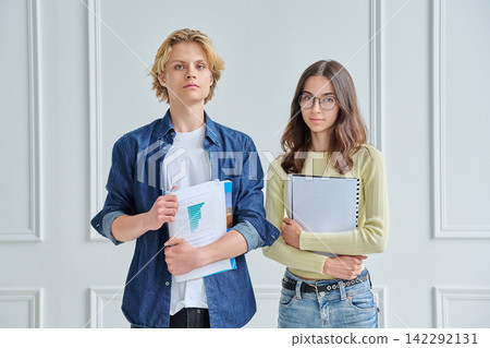 Portrait of two young college students standing together with study folders 142292131
