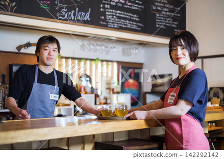 Male and female staff working at a cafe bar Male and female staff working at a cafe bar 142292142