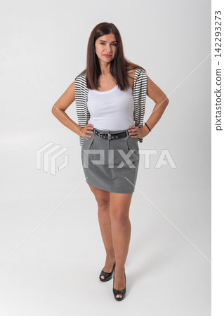Adult woman standing with hands on hips, showcasing a modern smart casual outfit against a clean white background, conveying confidence and professional elegance Adult woman standing with hands on hips, showcasing a modern smart casual outfit against a clean white background, conveying confidence and professional elegance 142293273