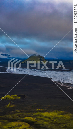Coastal view of moss-covered lava field with stratified volcano Coastal view of moss-covered lava field with stratified volcano 142293598