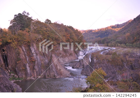The valley and Chidorigataki waterfall in Takinoue Park, Yubari, surrounded by autumn foliage. The valley and Chidorigataki waterfall in Takinoue Park, Yubari, surrounded by autumn foliage. 142294245