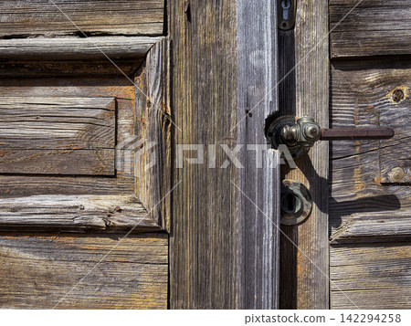 Weathered Rustic Wood Door with Vintage Lock Hardware - suitable for renovation, heritage design, vintage backgrounds, craftsmanship, old building textures, and traditional door concepts. Weathered Rustic Wood Door with Vintage Lock Hardware - suitable for renovation, heritage design, vintage backgrounds, craftsmanship, old building textures, and traditional door concepts. 142294258