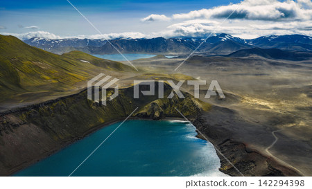Aerial view of crater lake with turquoise water and moss-covered slopes, ytra Iceland Aerial view of crater lake with turquoise water and moss-covered slopes, ytra Iceland 142294398