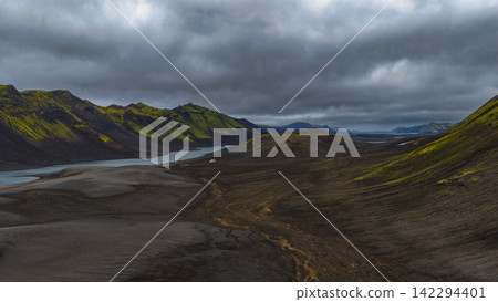 Aerial view of glacial valley with turquoise river and moss-covered mountains, Iceland Aerial view of glacial valley with turquoise river and moss-covered mountains, Iceland 142294401