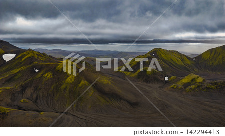 Aerial view of moss-covered volcanic peaks and dark lava plains, Iceland Aerial view of moss-covered volcanic peaks and dark lava plains, Iceland 142294413
