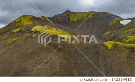 Moss-covered volcanic peaks with crater formation and residual snow, Iceland Moss-covered volcanic peaks with crater formation and residual snow, Iceland 142294418