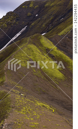 Hikers on moss-covered volcanic slope with meltwater stream, Skaft?rhreppur Iceland Hikers on moss-covered volcanic slope with meltwater stream, Skaft?rhreppur Iceland 142294435