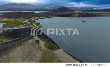 Aerial view of glacial lake with black sand shores and volcanic cones, Rang?r?ing ytra Iceland Aerial view of glacial lake with black sand shores and volcanic cones, Rang?r?ing ytra Iceland 142294532