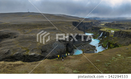 Aerial view of canyon with turquoise glacial meltwater and basalt cliffs, ytra Iceland Aerial view of canyon with turquoise glacial meltwater and basalt cliffs, ytra Iceland 142294533