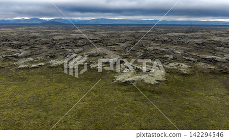 Aerial view of lava field with moss coverage and distant mountains, ytra Iceland Aerial view of lava field with moss coverage and distant mountains, ytra Iceland 142294546