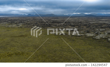 Aerial view of lava field with moss coverage and distant mountains, ytra Iceland Aerial view of lava field with moss coverage and distant mountains, ytra Iceland 142294547