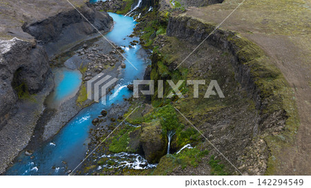 Aerial view of glacial river canyon with moss-covered cliffs and waterfalls,  ytra Iceland 142294549