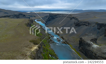 Aerial view of glacial river canyon with turquoise water and volcanic terrain, Rang?r?ing ytra Iceland Aerial view of glacial river canyon with turquoise water and volcanic terrain, Rang?r?ing ytra Iceland 142294553