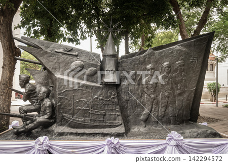 Dramatic high-relief bronze, this evocative monument depicts the valor and unified effort of armed forces across land, sea, and air. On the right, uniformed soldiers march forward in steadfast Dramatic high-relief bronze, this evocative monument depicts the valor and unified effort of armed forces across land, sea, and air. On the right, uniformed soldiers march forward in steadfast 142294572