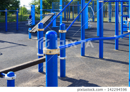 Outdoor exercise equipment at a municipal sports ground in a residential area. Sports equipment for exercise Outdoor exercise equipment at a municipal sports ground in a residential area. Sports equipment for exercise 142294596