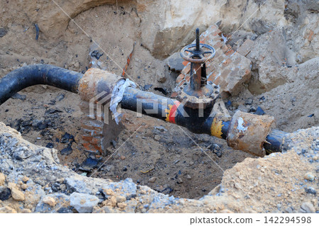Old Insulated Water Main Pipe and Shutoff Valve Exposed During Construction Work Old Insulated Water Main Pipe and Shutoff Valve Exposed During Construction Work 142294598