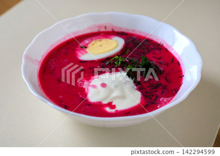 Traditional cold beet soup garnished with dill and sour cream in a white ceramic dish. Authentic national dishes and vegetarian meal. 142294599