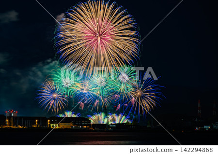 Colorful fireworks illuminating the night sky and the surface of the sea – a quintessential summer spectacle. Colorful fireworks illuminating the night sky and the surface of the sea – a quintessential summer spectacle. 142294868
