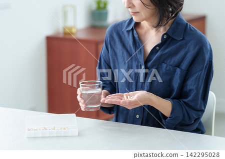 服用保健品的中年婦女的手 142295028